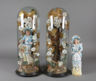 A pair of 19th Century German bisque and gilt decorated figures of a lady and gentleman 11" under glass domes in arbours with bisque flowers
