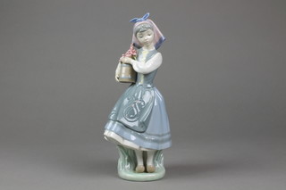 A Lladro figure of a young girl holding a jug of spring flowers 10 1/2"