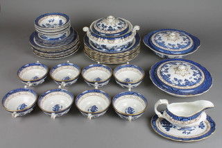 A Booths Real Old Willow pattern dinner service comprising 8 two handled bowls, 6 dessert bowls, 3 tureens and lid, a sauceboat and stand, 5 small plates, 8 side plates and 7 dinner plates 