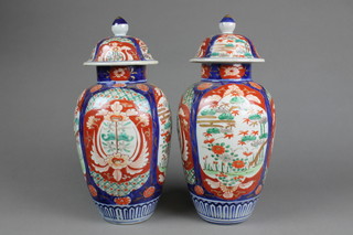 A pair of Imari oviform vases and and covers with panels of gardens and flowers 12" 