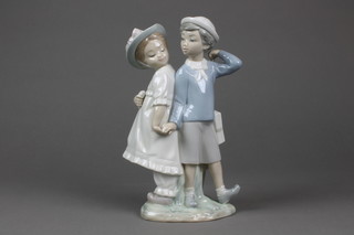 A Lladro group of a young girl and boy holding hands 10 1/2"