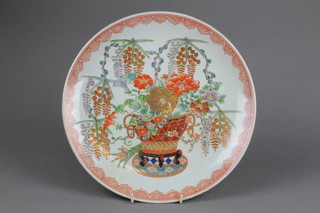 A 19th Century Imari shallow dish decorated with a vase of wisteria and flowers within a geometric border, red character mark to base 13"