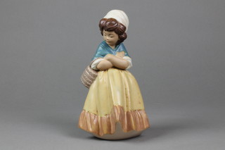 A Lladro tan glazed figure of a lady carrying a basket 8 1/2" 