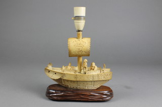 An early 20th Century bone model of a Chinese boat with figures on a hardwood stand 8" converted to electricity 