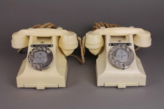 A pair of white Bakelite dial telephones, the bases marked 5677 
