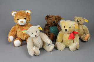 A Steiff Saturday teddybear 9", a Steiff Cosy Friend white bear 12", a Steiff yellow bear with articulated limbs 9", a Steiff light yellow teddybear 9" and a white Steiff bear 9"