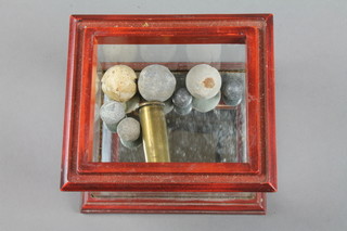 11 musket balls and a brass cartridge case 