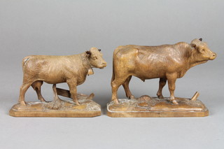 A pair of carved Swiss figures of a standing bull and cow, both 4 1/2"h (cow has old break and repair to horn)