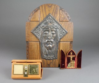 An olive wood crucifix with gilt metal figures contained in a leather folding case 5", an oak and embossed silver plated plaque depicting an image of christ 17" x 12" together with an Estyma travelling clock 