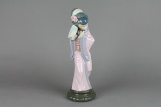 A Lladro figure of a Japanese lady holding a fan on a faux hardwood base 13"