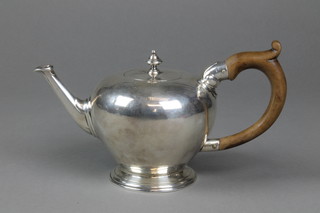 A George II baluster teapot with turned finial and splayed foot with fruitwood handle, London 1735, gross 13 1/2 ozs