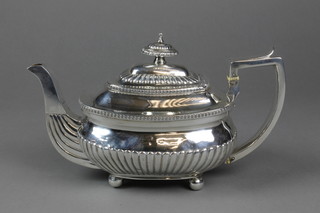 A Georgian silver rounded rectangular teapot with gadrooned decoration and demi-fluted body on ball feet, London 1808, maker RM, approx. 20 ozs 