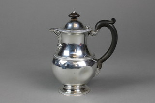 An Irish silver baluster hotwater jug with ebony mounts and acanthus spout with ribbed decoration, Dublin 1913, gross 17 ozs