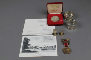 2 silver napkin rings, a silver commemorative medallion and 2 silver place markers etc