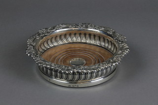 A George III silver wine coaster with shell and scroll rim and demi-fluted body, the fruitwood base engraved with a monogrammed plaque 7" 