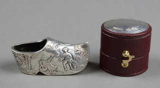 A Dutch repousse silver pin cushion in the form of a clog with a rural scene, a silver mounted and leather ring box