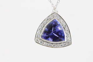 A white gold Art Deco style triangular cut tanzanite pendant, approx 3ct surrounded by 24 brilliant cut diamonds on an 18ct white gold chain