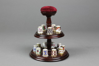 A collection of 15 Royal Crown Derby collector's thimbles on a 2 tier stand with pin cushion handle