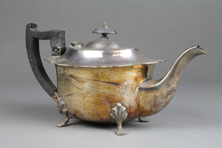 A silver plated oval teapot with ebony mounts on claw feet 