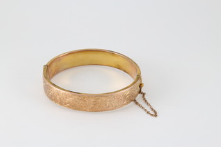 A 9ct gold hollow bangle with chased floral decoration, approx 13 grams