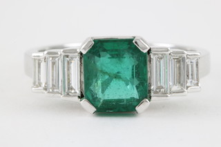 An 18ct white gold emerald and diamond ring, the centre stone approx. 1.25ct, flanked by 3 graduated diamonds, approx 0.5ct