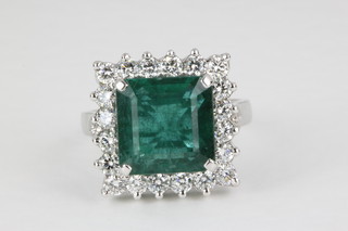 A 14 ct white gold square cut emerald and diamond ring, the centre stone approx. 7.3ct surrounded by 20 brilliant cut diamonds approx. 1.2ct 