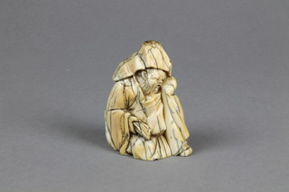 A good 19th Century ivory Okimono of a seated gentleman holding a scroll 2 1/2" 