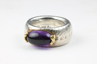 A silver dress ring set an oval cabouchon cut amethyst
