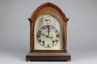 An Edwardian 8 day striking bracket clock with arched silvered dial contained in an inlaid mahogany lancet case raised on bun feet, slight damage to top of case