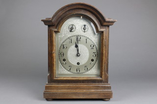 A German 8 day striking bracket clock, the 6 1/2" silvered arch shaped dial with Arabic numerals contained in an oak case