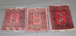 A red ground Afghan rug with 2 octagons to the centre and 2 other rugs all 26" x 20" 