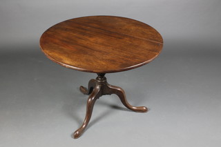A 19th Century circular mahogany snap top tea table raised on a turned column and tripod base 24"h x 32" diam.