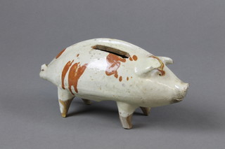 A naive Earthenware money bank in the form of a stylised pig with slip glazed decoration 8" 
