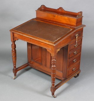 A Victorian walnut Davenport desk the back fitted a stationery box with hinged lid and fall front revealing a fitted interior with inkwell drawer, above 4 short drawers, raised on turned supports 37"h x 29"w x 25"d