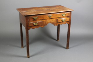A George II oak low boy fitted an arrangement of 3 drawers above a shaped apron, raised on square chamfered legs 29"h x 34"w x 18.5"d 