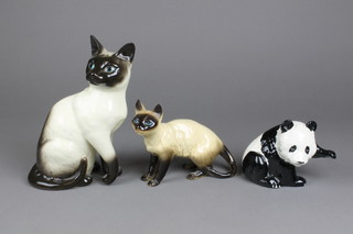 A seated figure of a Siamese cat 1882 10", another standing 7" and a Beswick figure of a seated Panda bear (f) 6" 