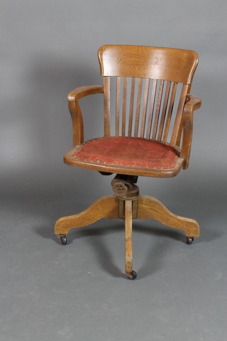 An Edwardian oak revolving tub back swivel office chair 