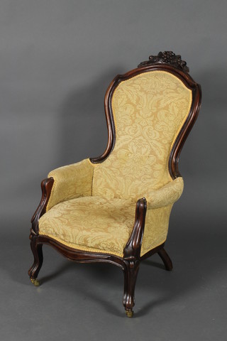 A Victorian carved mahogany show frame armchair, the seat of serpentine outline and upholstered in yellow material, raised on cabriole supports 