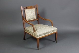 A Victorian inlaid rosewood open arm chair, the seat and back upholstered in green floral material, raised on square tapering supports 