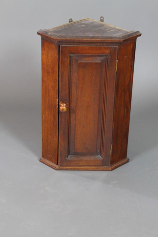 A Victorian oak hanging corner cabinet with moulded cornice, the interior fitted shelves enclosed by a panelled door 25 1/2"h x 17"d x 7 1/2"w