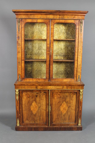 A Victorian inlaid figured walnut bookcase on cabinet, fitted adjustable shelves enclosed by D shaped panelled doors, the base fitted a double cupboard enclosed by panelled doors with gilt metal mounts throughout 77"h x 46"w x 14 1/2", possibly with associated base 