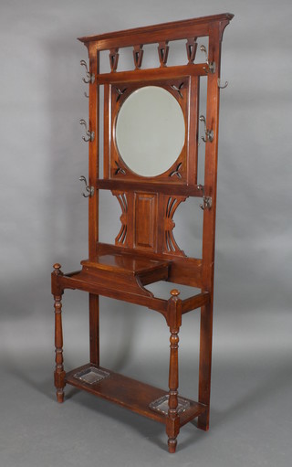 A Victorian mahogany hall stand the pierced back with circular bevelled plate mirror, the base fitted a glove box above a stick stand complete 2 drip trays, raised on turned supports 80 1/2"h x 33"w x 12"d 