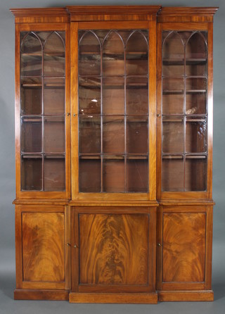 A handsome Georgian mahogany breakfront library bookcase, the upper section with moulded cornice, the interior fitted shelves enclosed by astragal glazed panelled doors, the base enclosed by 3 panelled doors, raised on a platform base 98"h x 67"w x 15"d