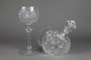 A cut crystal goblet on faceted stem 11", a ditto offset decanter and stopper 