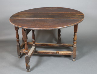 An 18th Century oak oval drop flap gateleg dining table fitted a drawer and raised on turned and block supports 28"h x 15"w x 49" when fully extended 