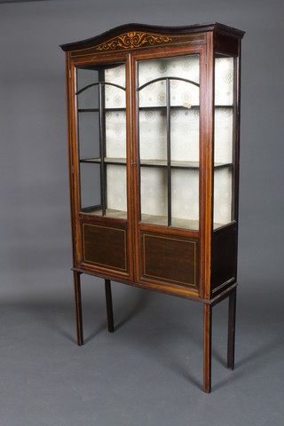 An Edwardian arch shaped inlaid mahogany display cabinet, the interior fitted shelves enclosed by astragal glazed doors, raised on square tapered feet 68"h x 36"w x 11 1/2"d 