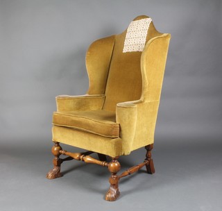 A Queen Anne style armchair upholstered in yellow dralon and raised on scrolled supports with turned stretcher