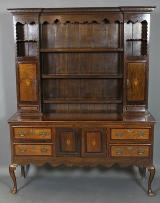A Georgian inlaid oak dresser, the raised back with moulded and dentil cornice fitted 3 shelves flanked by a pair of cupboards, the base fitted a cupboard enclosed by a panelled door flanked by 4 long drawers, raised on cabriole supports 88"h x 53"w x 18 1/2"d 