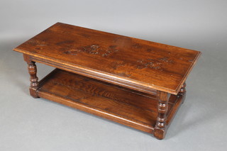 A rectangular oak 2 tier coffee table, raised on turned and block supports 17"h x 48"w x 22"d 