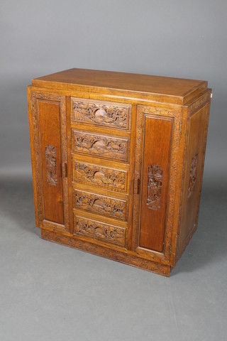 A 1930's carved Chinese hardwood cabinet, fitted 5 drawers flanked by a pair of cupboards 40"h x 36"w x 18"d 